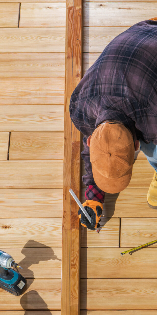 Caucasian Worker Building Wooden Deck For His Backyard Garden. Top View.